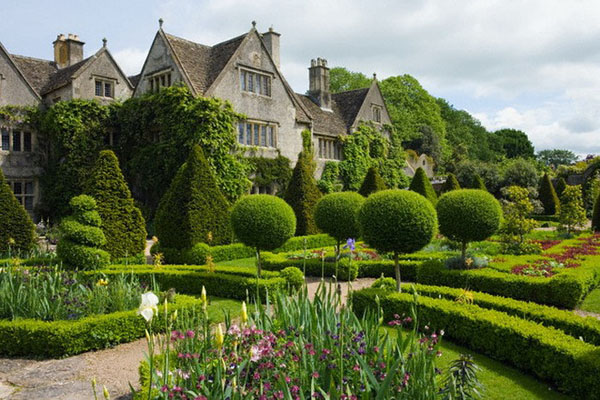 Malmesbury, England, UK --- Early summer at the Abbey House Garden, with the Manor House across the knot garden. --- Image by © Mark Bolton/Corbis